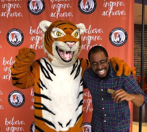 John Torrey Ph.D laughing and linked arms with the Buffalo State tiger mascot